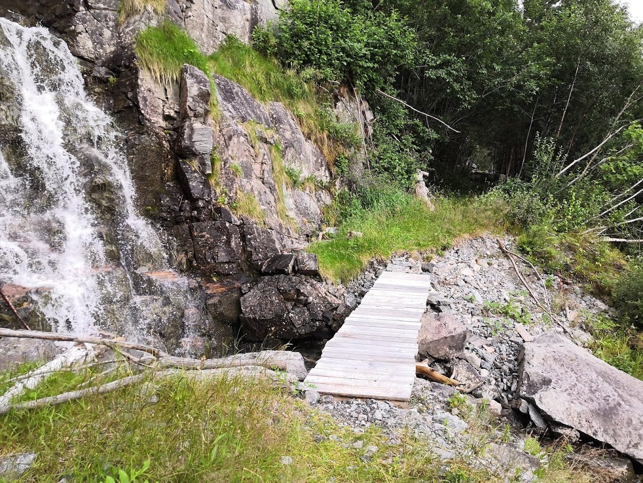 A small wooden bridge makes it possible to cross a stream of water on the old road